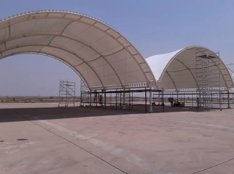 Two tall arched tensile bays under construction