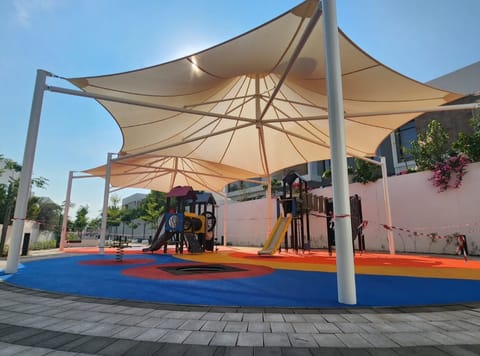 Four-point sand shade over playground equipment on coloured flooring