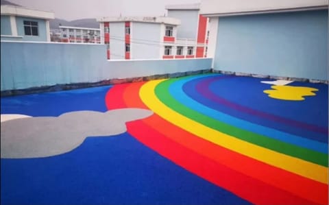 Rubber play flooring with a rainbow and cloud design